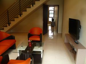 卡里乌昂亭豪斯度假屋的客厅配有橙色椅子和电视