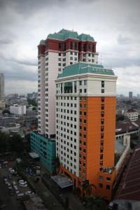 雅加达阿卡迪亚曼加杜亚酒店的一座橙色和白色的高楼