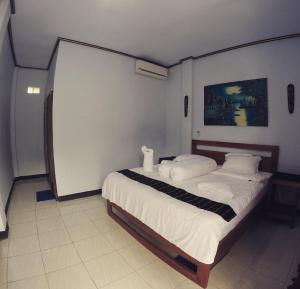 纳闽巴霍丹克旅馆 的一间卧室配有带白色床单和枕头的床。