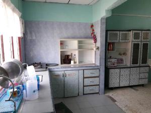 太平尤斯塔兹民宿的厨房配有柜台和冰箱。