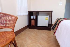 清莱拉蒂莎旅馆的客房设有床、椅子和冰箱。