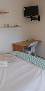 伊丽莎白港Humewood Home Stay的一间卧室配有一张带书桌和电视的床。