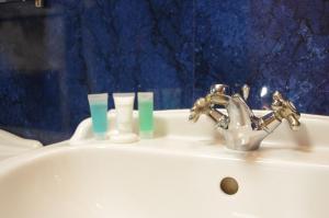 LangsettThe Dog and Partridge的浴室水槽配有水龙头和蜡烛