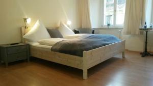 于伯林根K-Hotel (Grüner Baum)的一间卧室配有一张带枕头的大床