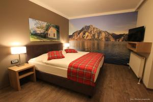 SierningGasthof Alpenblick的一间带一张床的卧室,并画着一幅山画