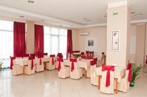 索非亚阿斯特拉酒店的宴会厅配有桌椅和红色弓