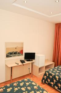 索非亚阿斯特拉酒店的客房设有一张书桌、一台电脑和一张床