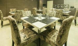 加尔各答Treebo Trend Hoops - Airport的一间配备有白色桌椅的用餐室