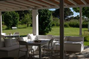 VromolimnosSkiathos Holidays Suites & Villas的庭院配有白色的沙发和桌椅