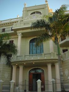 博卡奇卡佛罗伦萨别墅酒店的前面有棕榈树的建筑