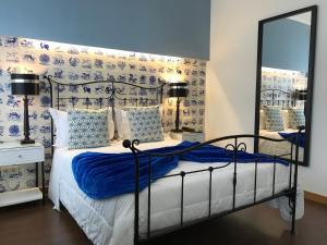 阿威罗迎宾旅舍的一间卧室配有一张床和镜子