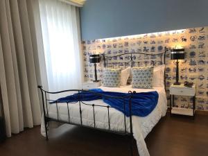 阿威罗迎宾旅舍的一间卧室配有一张蓝色墙壁的床