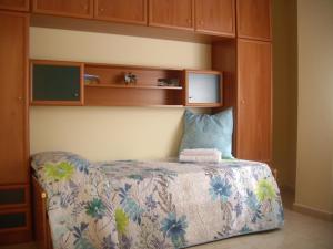 拉斯加莱塔斯塞里玛尔公寓的一间卧室配有一张床和木制橱柜