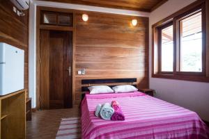 圣多美Albergaria Porcelana的一间卧室配有一张带粉色毯子的床