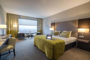 杜塞尔多夫杜塞尔多夫机场凡德瓦克酒店的酒店客房设有一张大床和一张书桌。