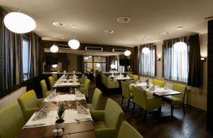 奥伯霍夫Konsumhotel Oberhof - Berghotel Oberhof的餐厅设有桌子和黄色的椅子及灯
