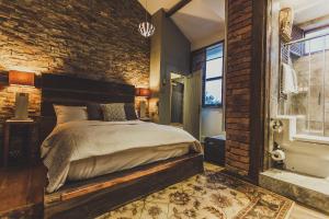 曼彻斯特牛洞酒店的一间卧室设有一张床和砖墙