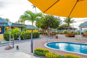 棕榈滩MVC鹰湾酒店的一个带遮阳伞和桌椅的度假游泳池