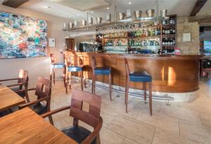 布罗德韦拉塞尔酒店的餐厅内的酒吧配有木桌和椅子