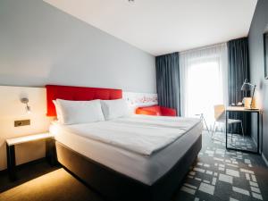 克拉科夫克拉科夫Q酒店的酒店客房,设有床铺和红色床头板