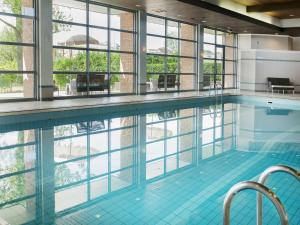 埃因霍温埃因霍温凡德瓦克酒店的一个带窗户的大型游泳池和一个大型游泳池