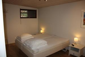 斯卡恩Skagen Ferie 1的一间卧室配有带白色床单和枕头的床。