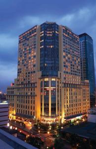 马尼拉New Coast Hotel Manila (formerly New World Manila Bay Hotel)的前面有灯的大建筑