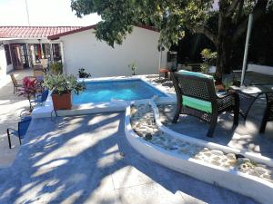 马那瓜米拉多住宿加早餐旅馆的一个带两把椅子和一张桌子的游泳池以及一张长凳