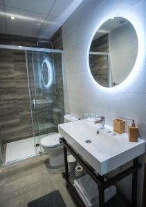 马拉加The Lights City Rooms的一间带水槽、卫生间和镜子的浴室