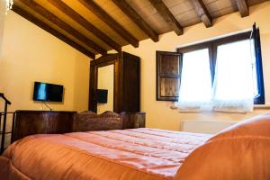 PatricaLa Tenuta del Campo di Sopra的一间卧室设有一张大床和一个窗户。