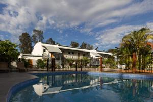布里斯班诺维娜棕榈汽车旅馆的一座带围栏的房屋前的游泳池