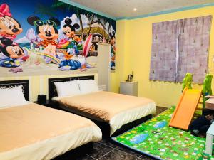 Zhixue吾居吾宿的一间卧室配有两张床和一张麦克奇老鼠壁画