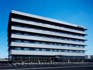 岛田HATAGO INN Shizuoka Yoshida IC的一座大型办公楼,有很多窗户