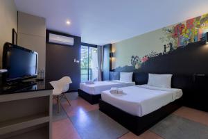 乌汶盘塔哈格酒店的酒店客房设有两张床和一台平面电视。