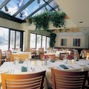 阿尔塔斯诺伯德旅舍的一间设有白色桌椅和窗户的用餐室