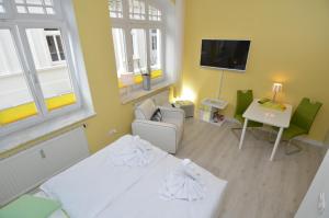 宾茨Villa Sirene - Wohnung 08的客房设有床、沙发和电视。