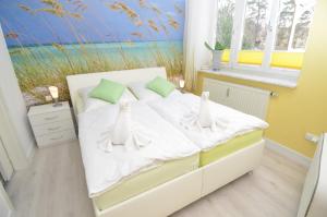 宾茨Villa Sirene - Wohnung 08的一间卧室配有一张带白色床单的床和一扇窗户。