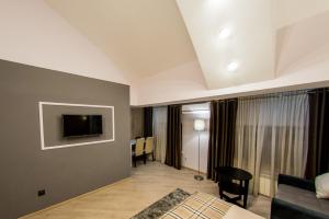 基希讷乌Mon Ami Villa的客厅配有沙发和墙上的电视