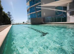 黄金海岸海滨沉思酒店的大楼前的游泳池