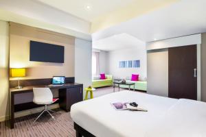 沙迦ibis Styles Sharjah的酒店客房配有一张床、一张书桌和一台电脑