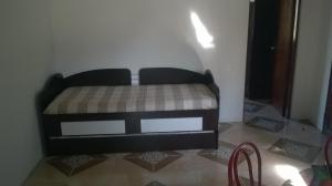 皮里亚波利斯Flomar的一张小床,位于客房的角落