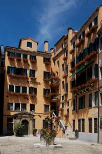 威尼斯阿尔科德伽酒店的一座大型建筑,旁边是植物