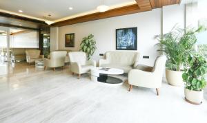 古尔冈Treebo Tryst Eden Residency的一间设有白色家具和盆栽植物的等候室