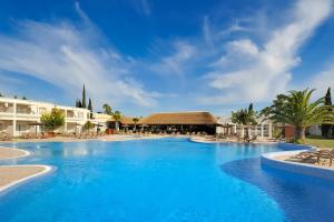 奇克拉纳－德拉弗龙特拉文奇海岸高尔夫度假酒店的一座大型游泳池,其背景是一座度假村