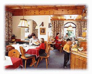 巴德加斯坦兰德豪斯赫勒斯黑慕赫尔酒店的一群人坐在厨房的桌子上