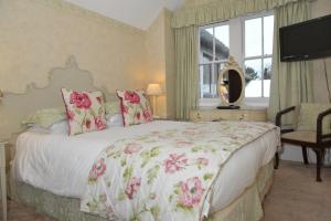 博格诺里吉斯英格尔努克酒店的一间卧室配有一张带粉红色花卉的大床