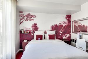 巴黎巴黎巴士底玛莱斯美居酒店的卧室配有带红色枕头的大型白色床
