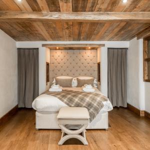 Dalbury LeesThe Cow Dalbury的一间卧室设有一张大床和木制天花板