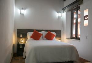 卡塔赫纳卡塔赫纳盖瑟马尼酒店的卧室配有带红色枕头的大型白色床
