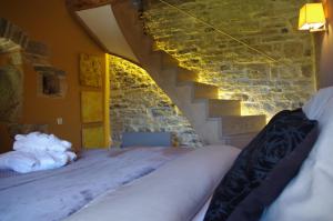 CaylusLe Mas de Laché的一间卧室设有两张床和石墙